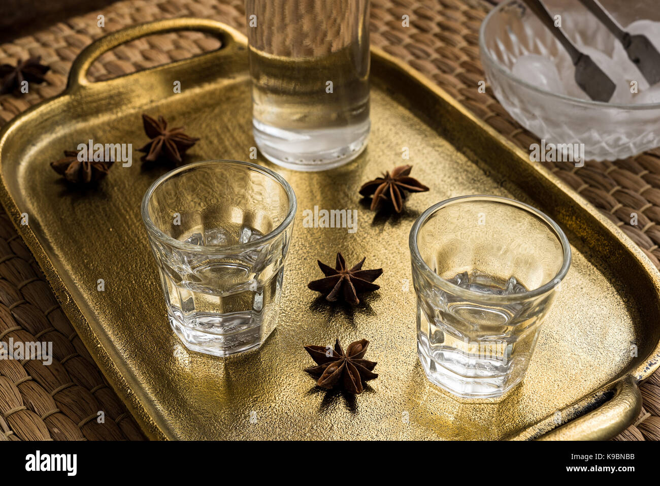 Glasses of traditional drink Ouzo or Raki on bronze dish with anise