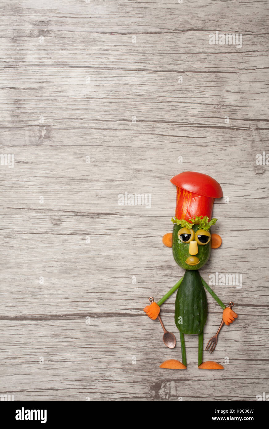 Funny cucumber cook made on wooden background Stock Photo
