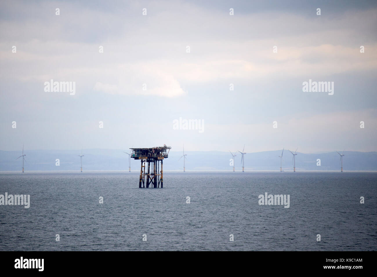 hamilton unmanned satellite platform part of the douglas oil complex in the irish sea in front of offshore wind farm north wales Stock Photo