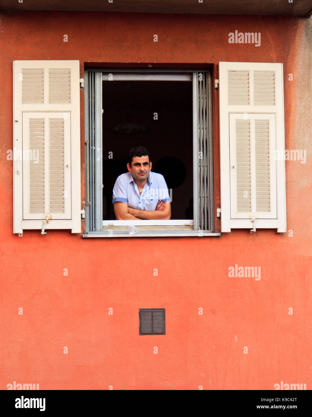 Senior man looking out of window in a loft flat stock photo