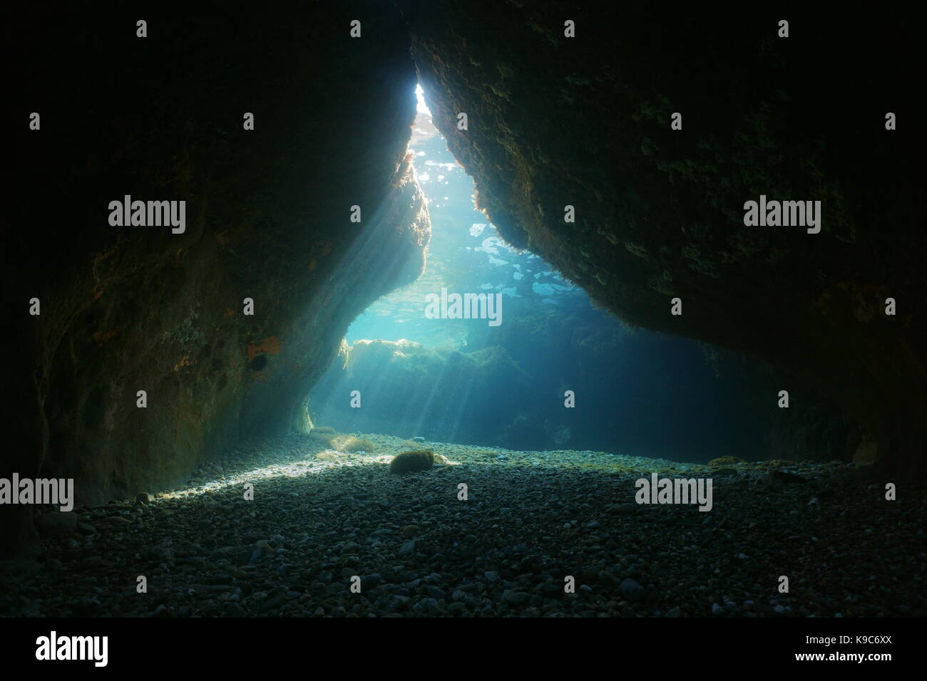 Exit of a cave underwater with natural sunbeams, Mediterranean sea, Pyrenees Orientales, Roussillon, France Stock Photo