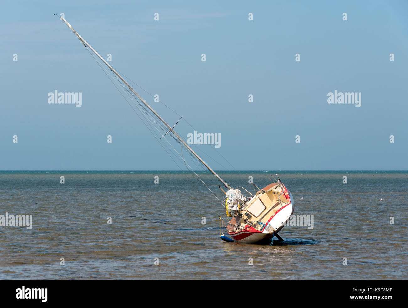 Sailing boat at low tide resting on its side Stock Photo