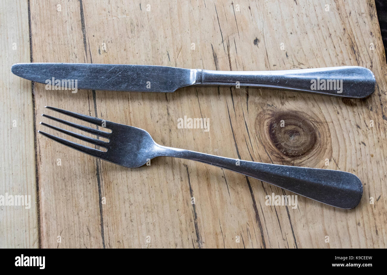 Detail of a Knife and Fork on an Old Rustic Oak Table, Ready for a Meal