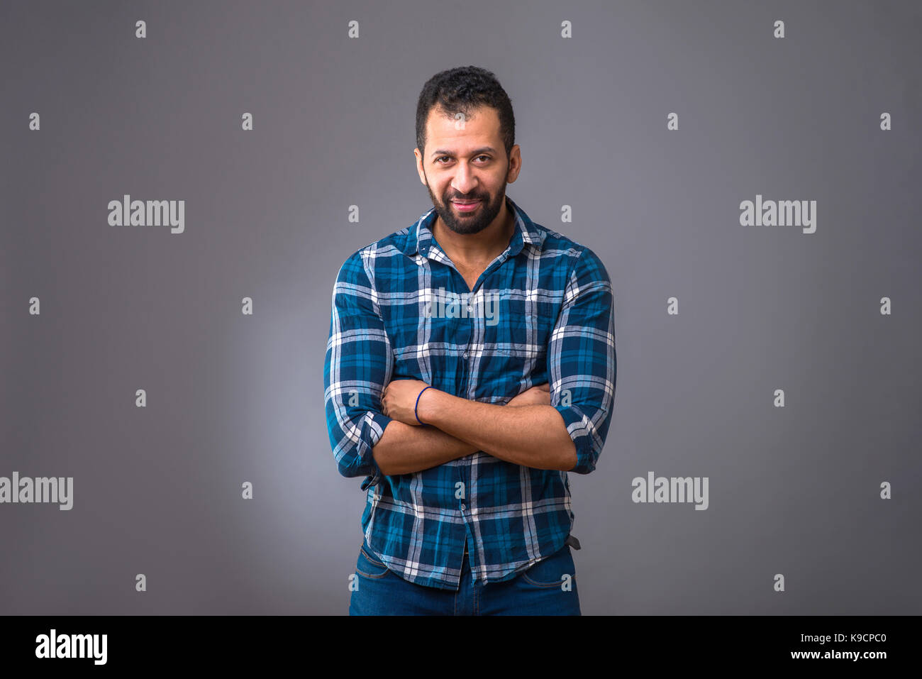 A young black man standing confidently with his arms folded Stock Photo ...