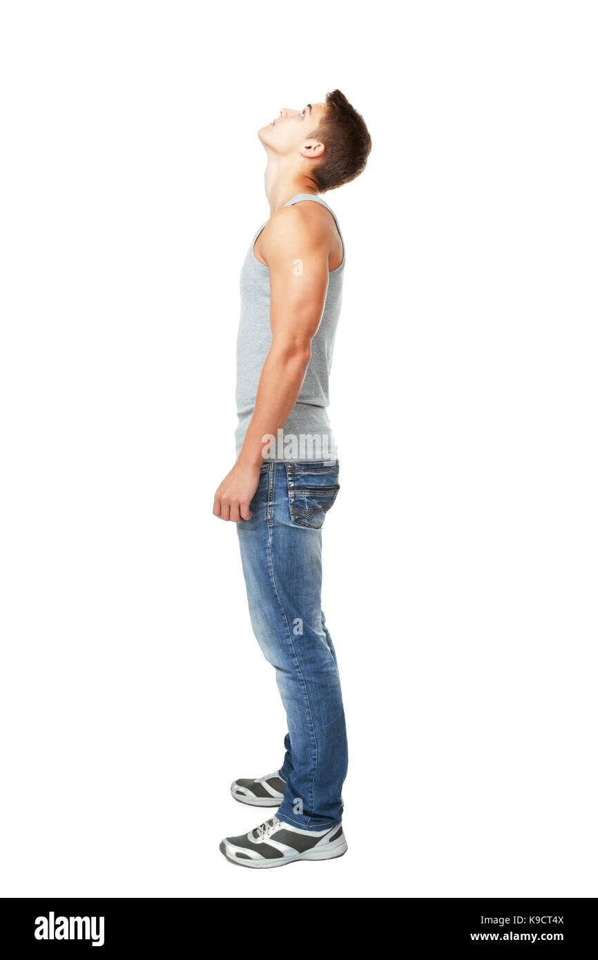 Full length side view portrait of young man looking up isolated on white background Stock Photo