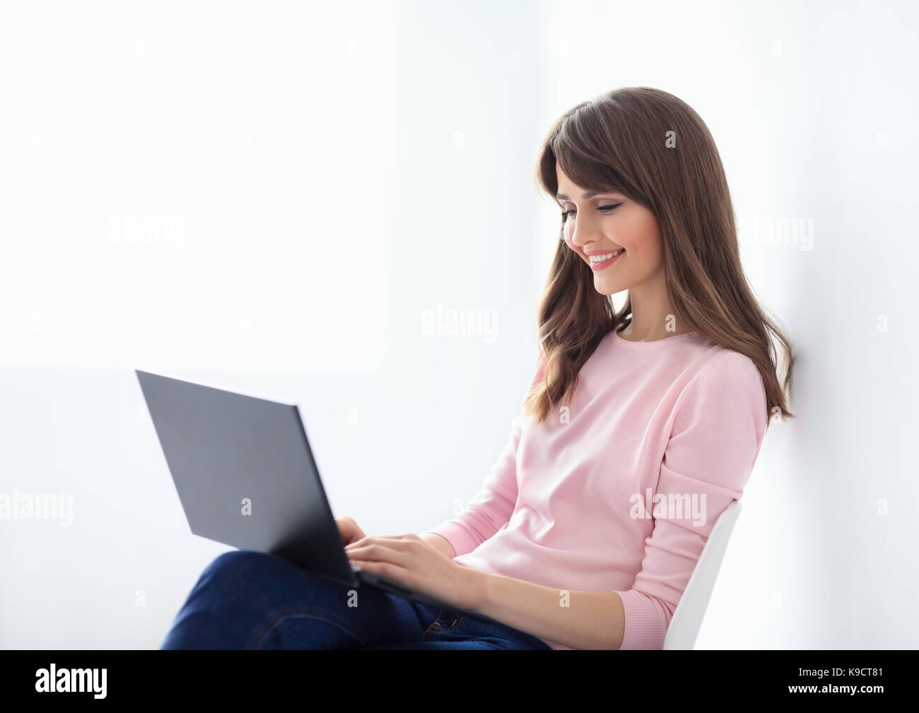 Smiling beautiful woman portrait with laptop on white background Stock ...