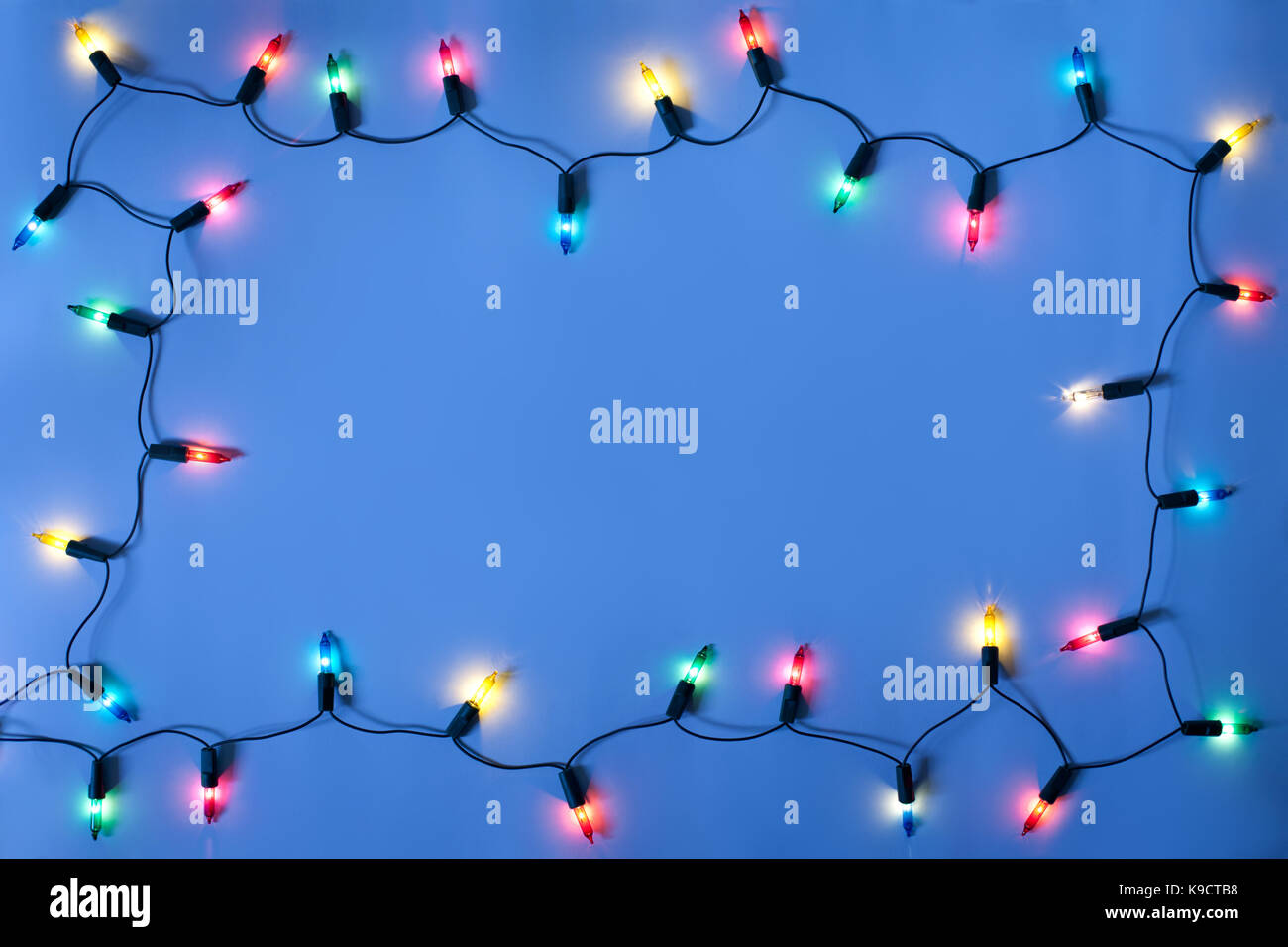 Christmas lights frame on dark blue background with copy space.Decorative garland Stock Photo