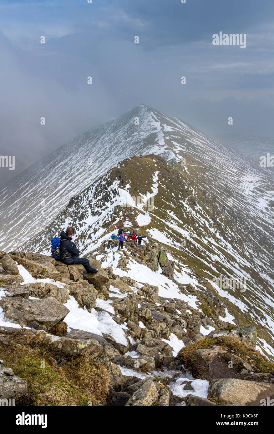 Walkers Making Their Way up Swirral Edge with the View Towards Catstye Cam Behind, Helvellyn Range, Lake District, Cumbria, UK Stock Photo