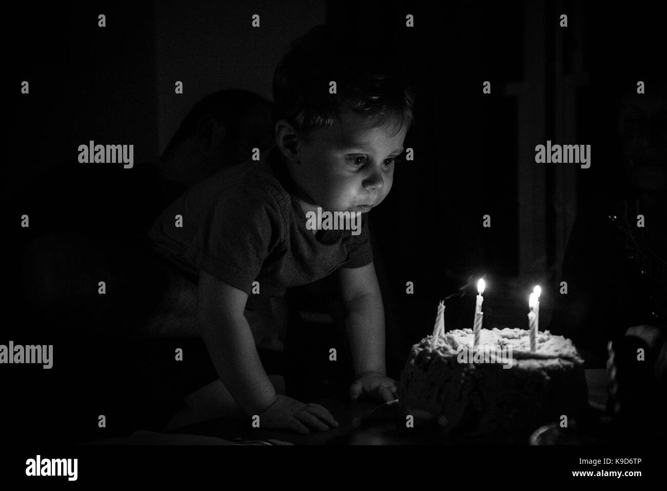 Toddler Boy blowing out candles on his birthday cake Stock Photo
