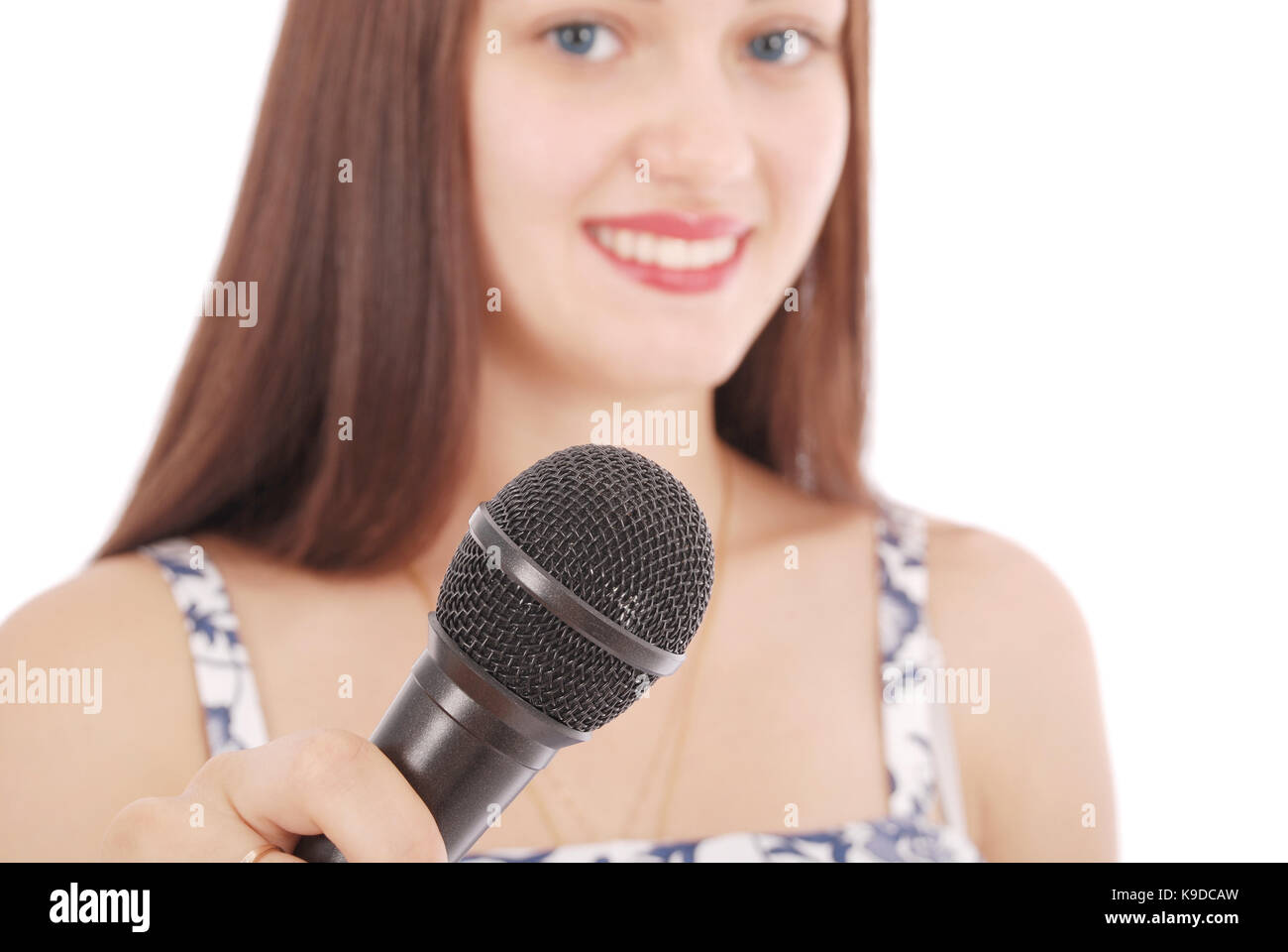 Happy young beautiful girl singing with microphone isolated on white