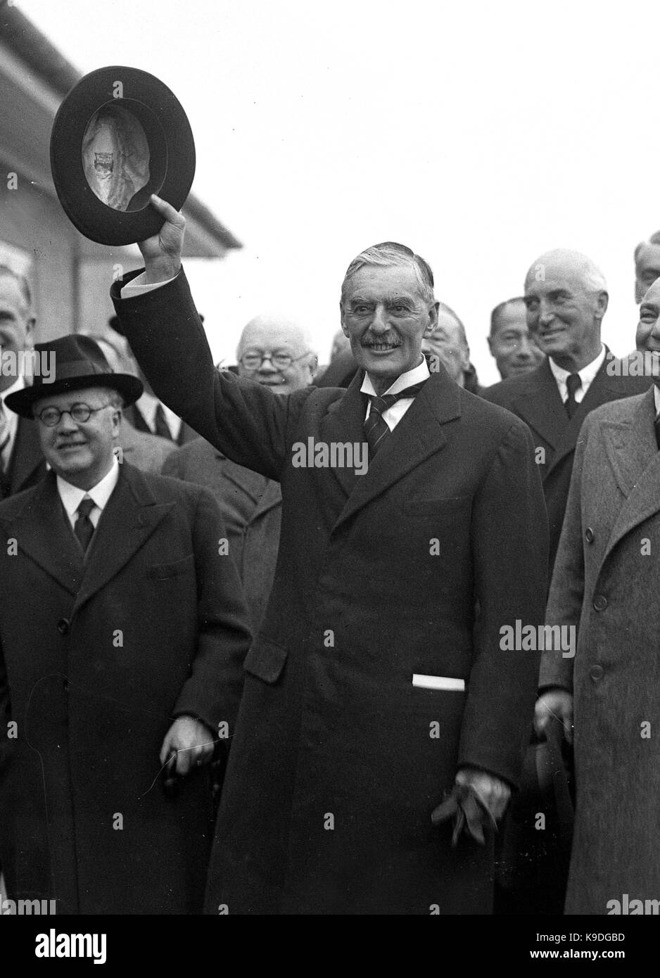 British prime minister Neville Chamberlain after returning from his summit meeting with the German Chancellor Adolf Hitler in Munich. Prime Minster Chamberlain returned with the paper signed by Hitler and himself sticking out of his pocket after declaring to the waiting crowd ' Peace in our time ' 3rd October 1938. With him is Sir Kingsley Wood Stock Photo