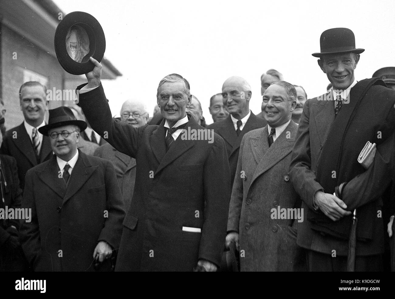 British prime minister Neville Chamberlain leaving for his summit meeting with the German Chancellor Adolf Hitler in Munich. Prime Minster Chamberlain returned with the paper signed by Hitler and himself sticking out of his pocket after declaring to the waiting crowd ' Peace in our time ' 3rd October 1938. With him are Sir Kingsley Wood, Leslie Hore-Belisha, Lord Halifax. Stock Photo