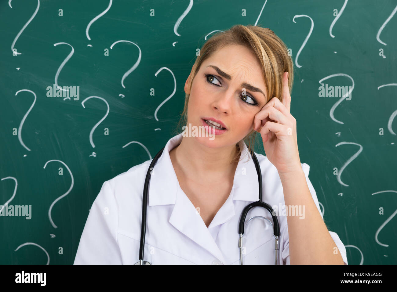 Female Doctor Standing In Front Of Blackboard With Question Mark Signs Stock Photo Alamy