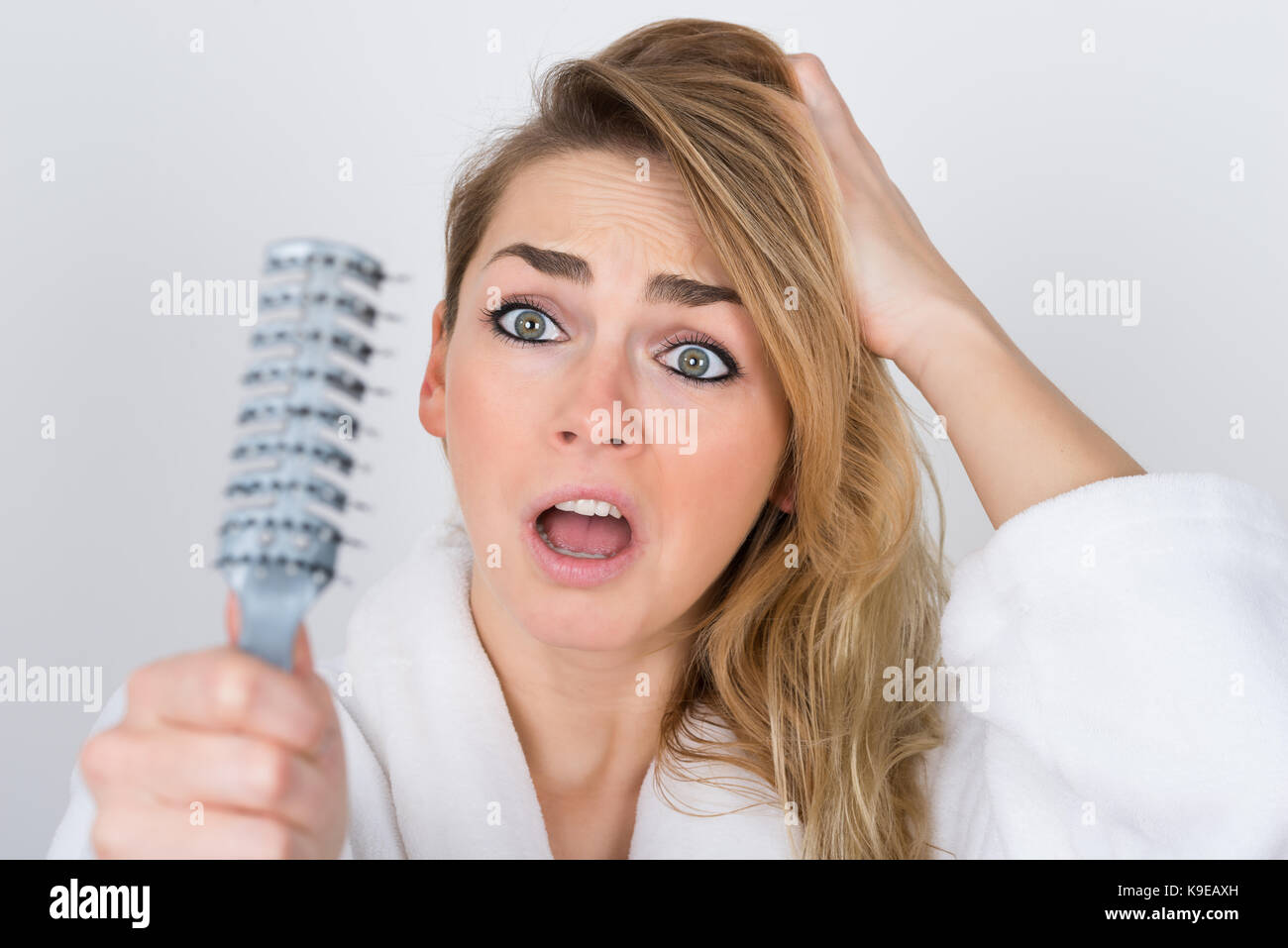 Worried Woman Suffering From Hairloss Looking At Comb Stock Photo