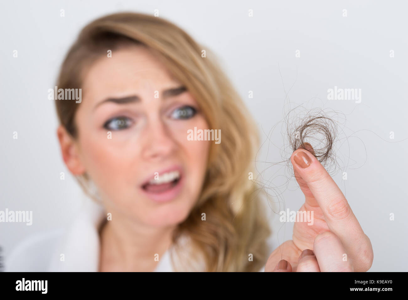 Close-up Of Worried Woman Holding Loss Hair Stock Photo