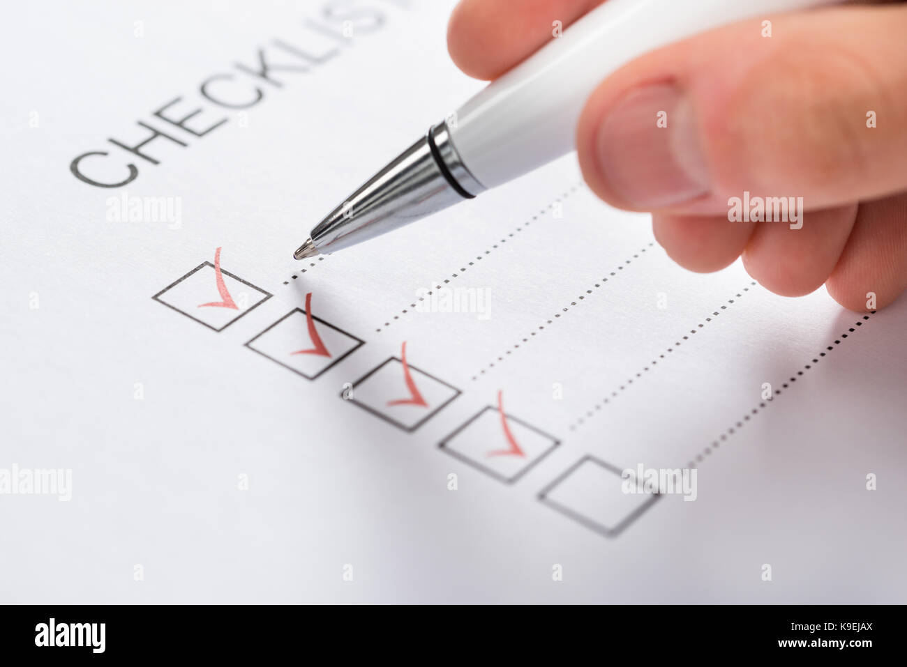Close-up Of Silver Pen Over Filled Checkboxes In Form Stock Photo