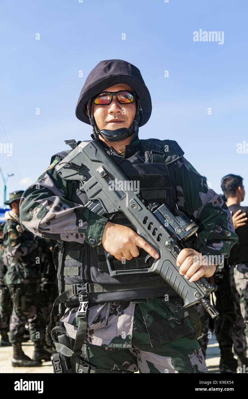 A Filipino National Policeman in the Special Boat Unit is on display in full camo uniform and carries the compact version of a Tavor CTAR 21 assault r Stock Photo