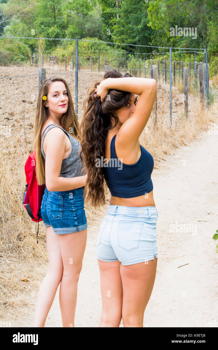 Two beautiful women hiking in nature on a mountain road Stock Photo - Alamy