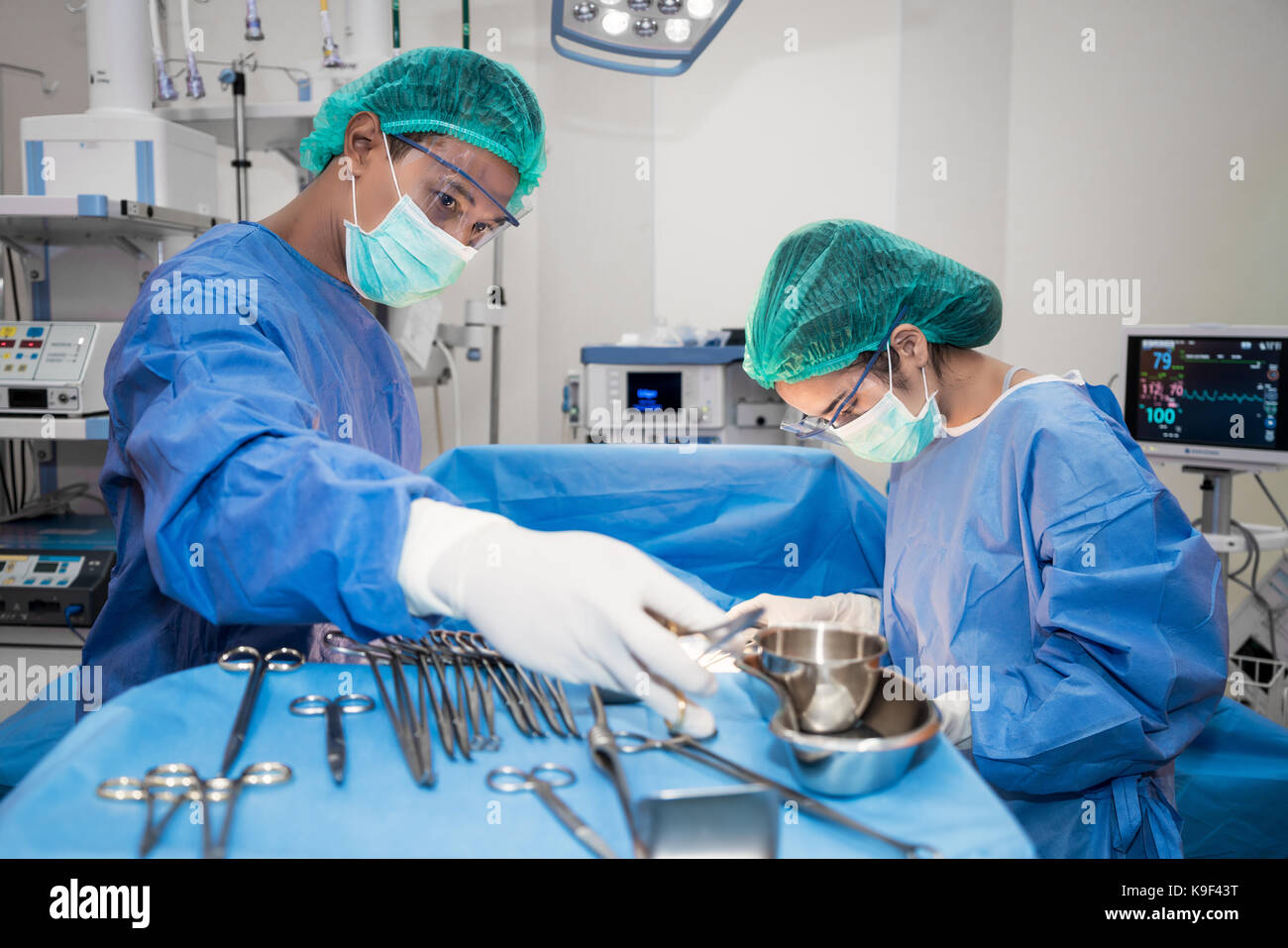 Asian doctor and an assistant in the operating room for surgical venous