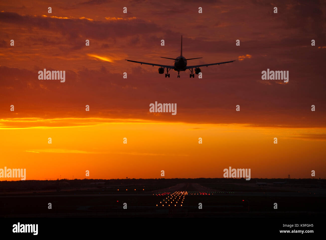 A commercial airliner landing at sunset Stock Photo Alamy