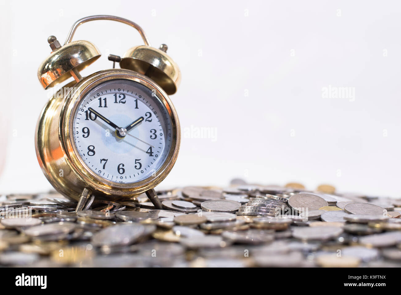 Golden Bell Clock On A Group Of Coins Time Is Gold Money Concept Malaysia Currency Stock Photo Alamy