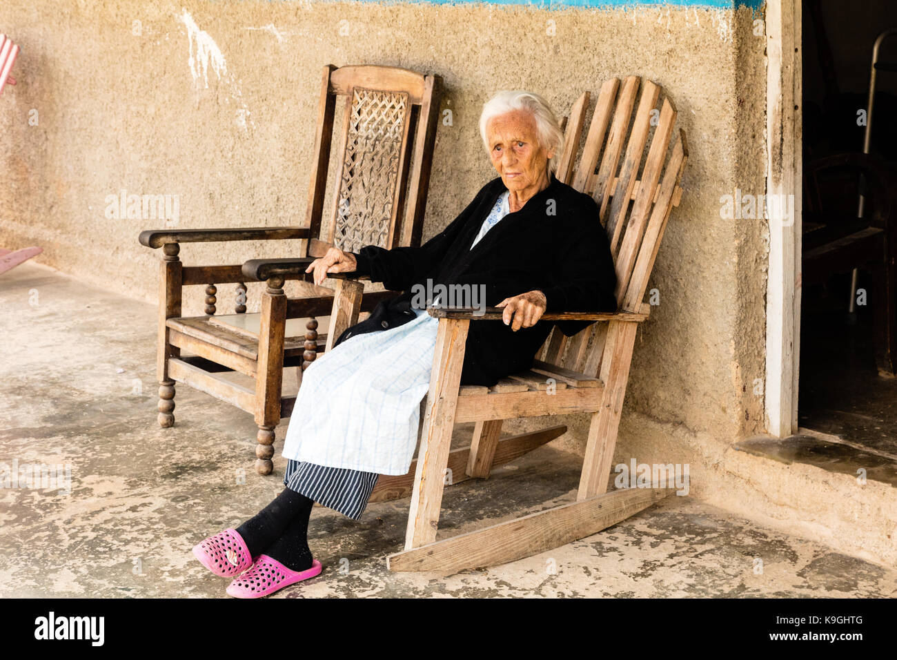 Smiling White Haired Old Lady Sitting On A Wooden Rocking Chair