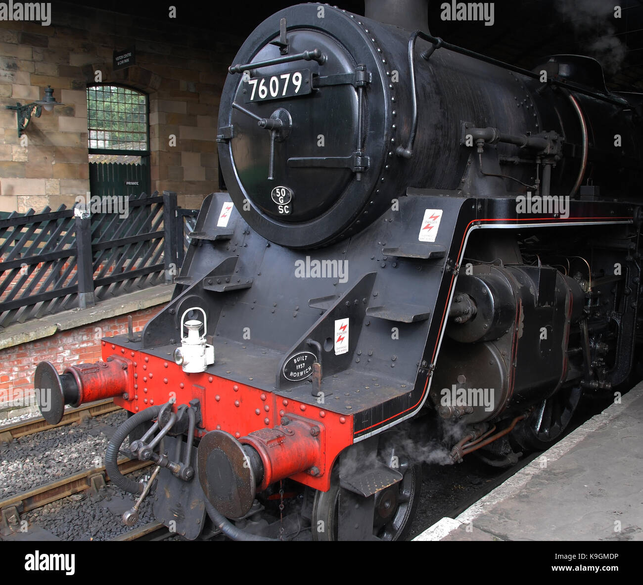 A close up view of the front of an old British steam locomotive stationary at a platform Stock Photo