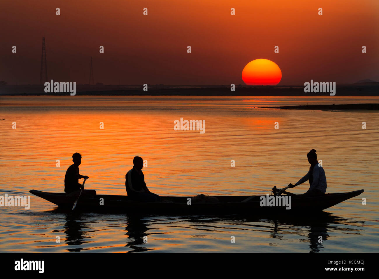 Boat at sunset on the Brahmaputra river, Assam, India Stock Photo