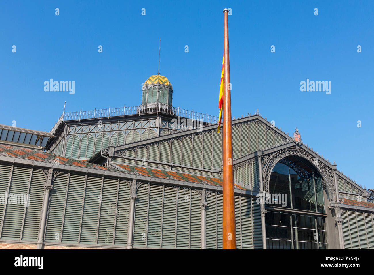 The facade of Born market, and flag of Catalonia. It is an example of iron architecture, a movement within the modernist. Born district. Barcelona, Stock Photo