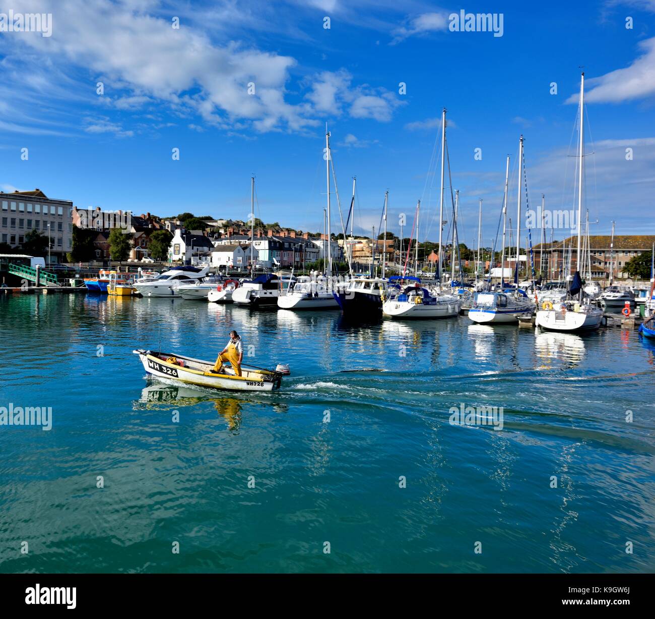 A local fisherman leaving Weymouth harbour in a small motorboat Dorset UK Stock Photo