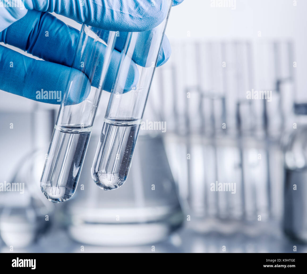 Laboratory beakers in analyst's hand in plastic glove Stock Photo Alamy