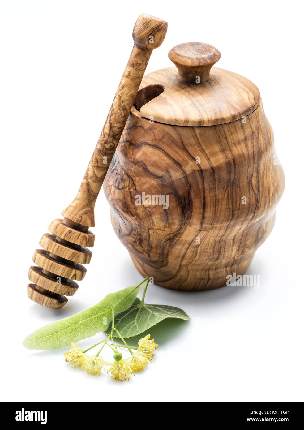 Wooden pot full of fresh linden honey and linden flowers. Stock Photo