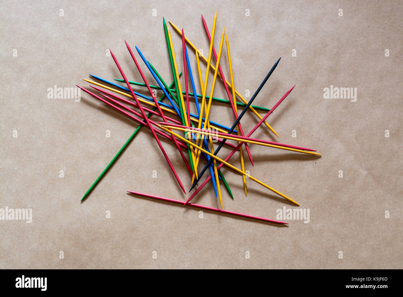 Pick up Sticks - a random pile of coloured wooden sticks with sharp points. On a brown background. Can be a puzzle or a competition. Stock Photo