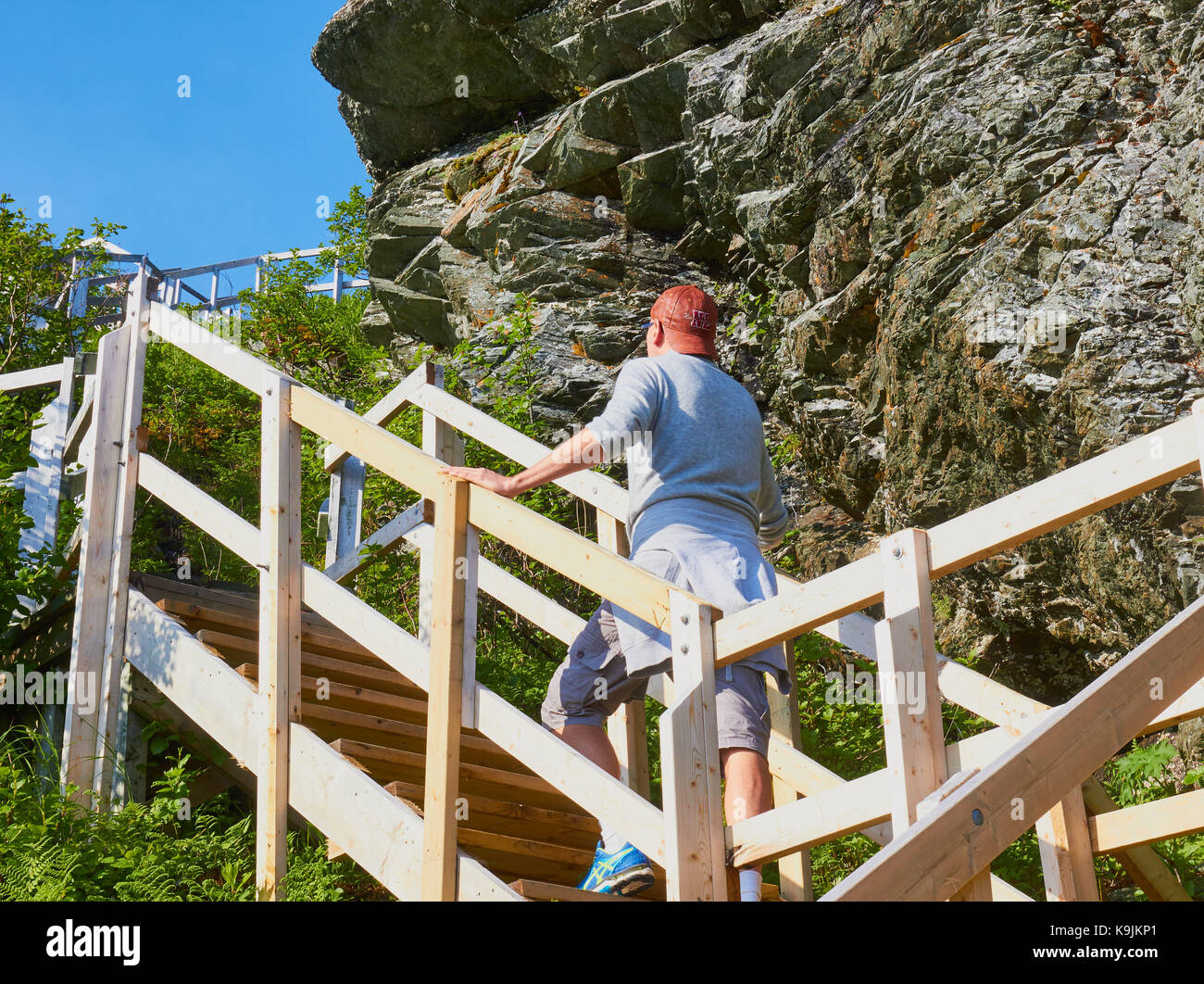 Middle aged Swedish male tourist climbing up Daredevil Trail, Fishing Point Head, St Anthony, Newfoundland, Canada. Concept, lifestyle, exercise Stock Photo