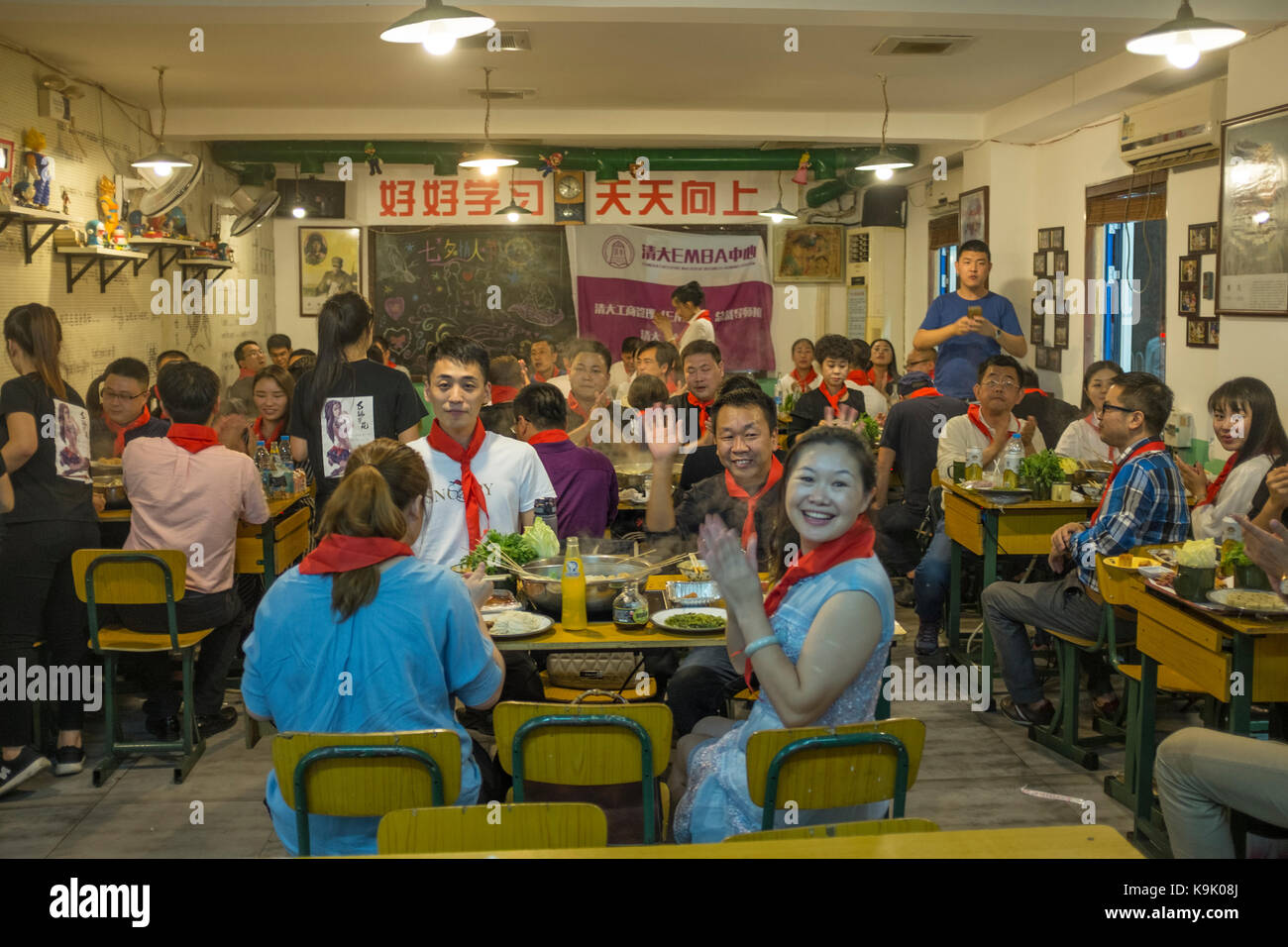Beijing, China  23rd Sep, 2017. Chinese guests wear red scarves of Young Pioneers in a hot pot restaurant in Beijing, China,  23th September 2017. While nobody wants a return to the period of turbulence that China endured during the 1960s and 1970s, a few restaurants keep the fervor of revolution alive with their communist-kitsch decor and socialist song-and-dance shows. The Chinese characters on the wall read 'Good good study, day day up' -  quotation from Chairman Mao.  Lou Linwei/Alamy Live News Stock Photo