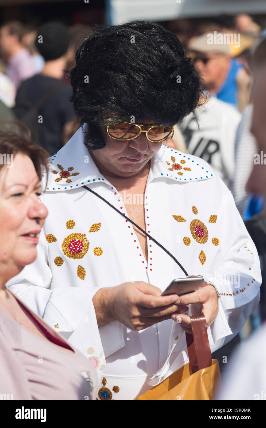 Elvis Presley look-a-like checks his mobile phone / cell phone Stock Photo