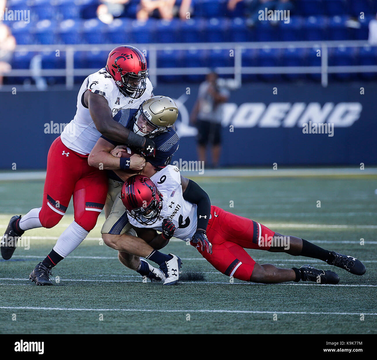 Annapolis, Maryland, USA. 23rd Sep, 2017. United States Naval Academy QB #9 Zach Abey is tackled by Cincinnati Bearcats LB #6 Perry Young and Cincinnati Bearcats DE #44 Marquise Copeland during a NCAA football game between the United States Naval Academy Midshipmen and the Cincinnati Bearcats at Navy Marine Corp Stadium in Annapolis, Maryland. Justin Cooper/CSM/Alamy Live News Stock Photo