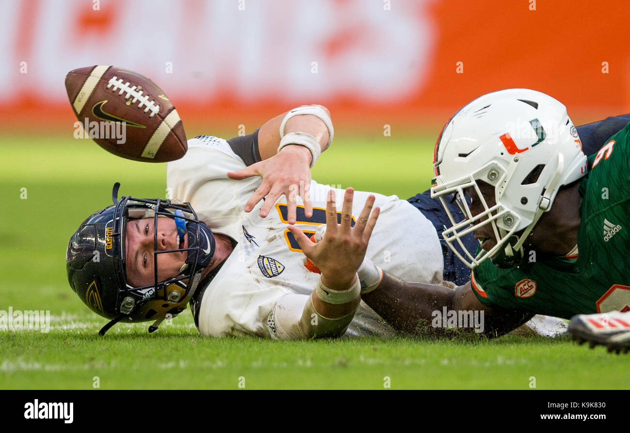 Miami Gardens, Florida, USA. 23rd Sep, 2017. Toledo Rockets quarterback Logan Woodside (11) reaches for his fumble knocked loose by Miami Hurricanes defensive lineman Chad Thomas (9) but can't retrieve it. Miami Hurricanes defensive back Sheldrick Redwine (22) recovered the fumble at Hard Rock Stadium in Miami Gardens, Florida on September 23, 2017. Credit: Allen Eyestone/The Palm Beach Post/ZUMA Wire/Alamy Live News Stock Photo