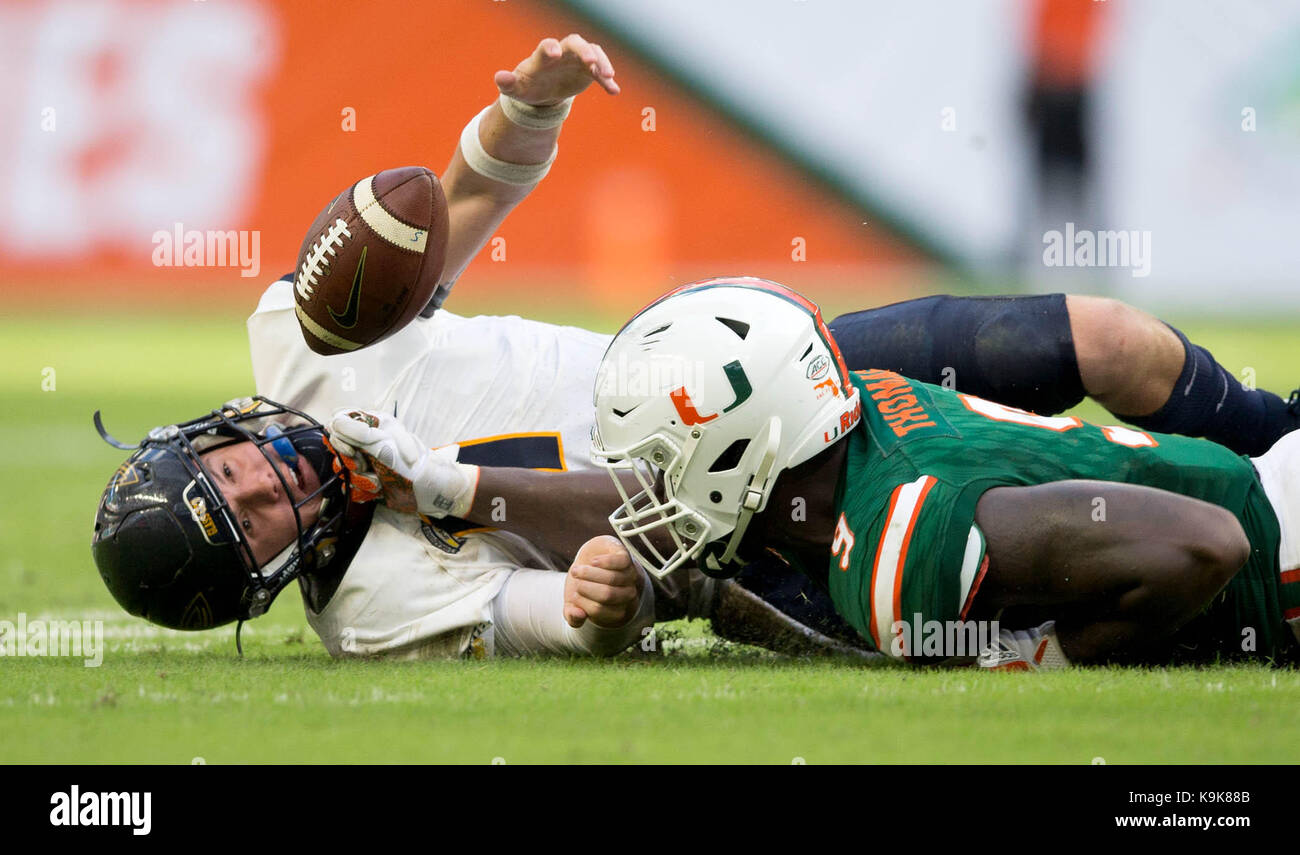 Miami Gardens, Florida, USA. 23rd Sep, 2017. Toledo Rockets quarterback Logan Woodside (11) reaches for his fumble knocked loose by Miami Hurricanes defensive lineman Chad Thomas (9) but can't retrieve it. Miami Hurricanes defensive back Sheldrick Redwine (22) recovered the fumble at Hard Rock Stadium in Miami Gardens, Florida on September 23, 2017. Credit: Allen Eyestone/The Palm Beach Post/ZUMA Wire/Alamy Live News Stock Photo