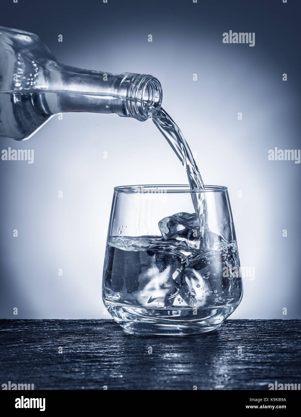 Pouring alcohol into a glass. Monochrome picture. Stock Photo