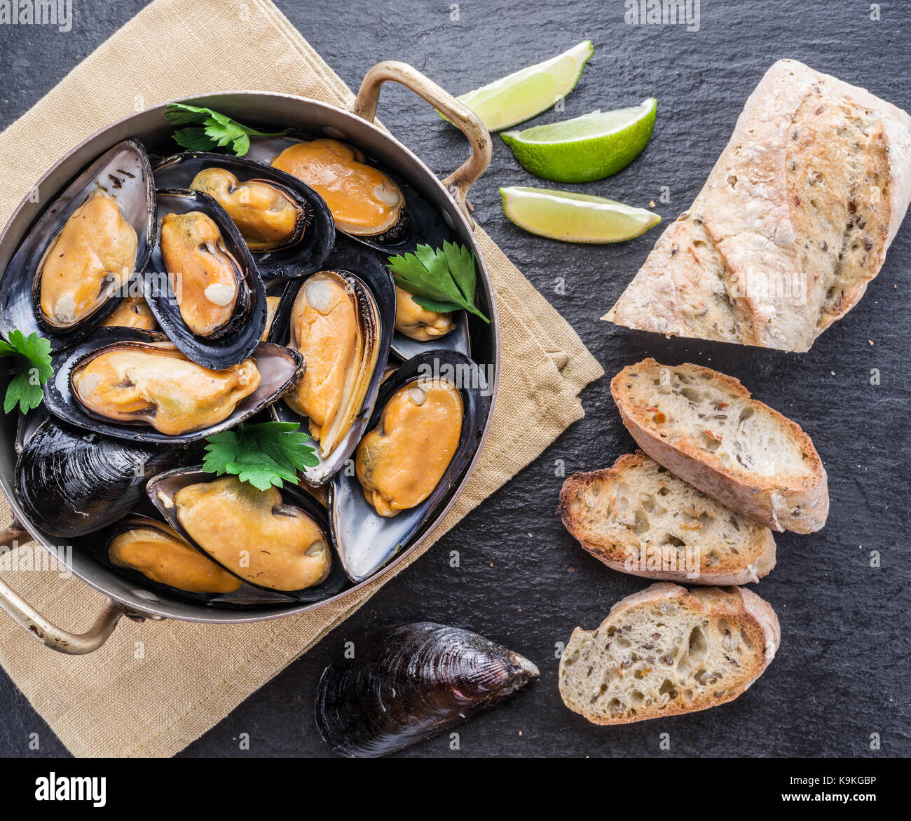 Boiled mussels in copper pan on the graphite background. Stock Photo