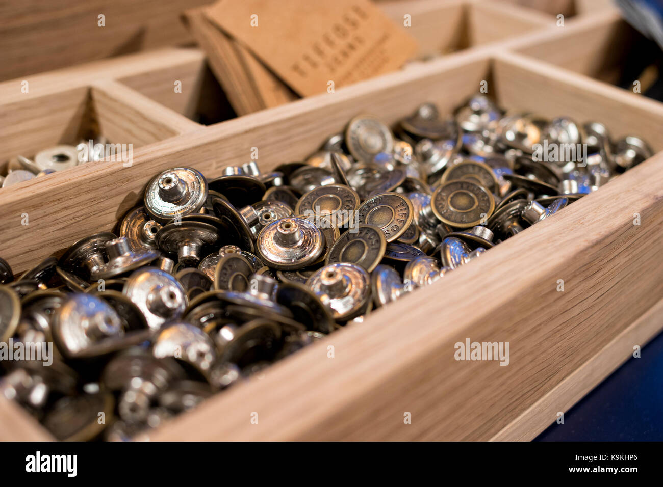 Wooden box full of Tiffosi brand tack buttons. Stock Photo