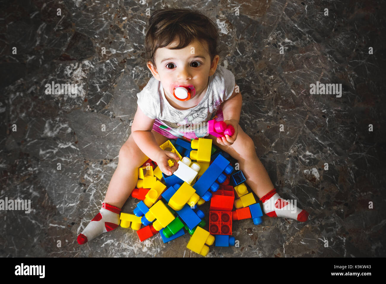 newborn play building blocks - colorful toy bricks - above view of a baby playing with toy bricks - little child play on floor Stock Photo
