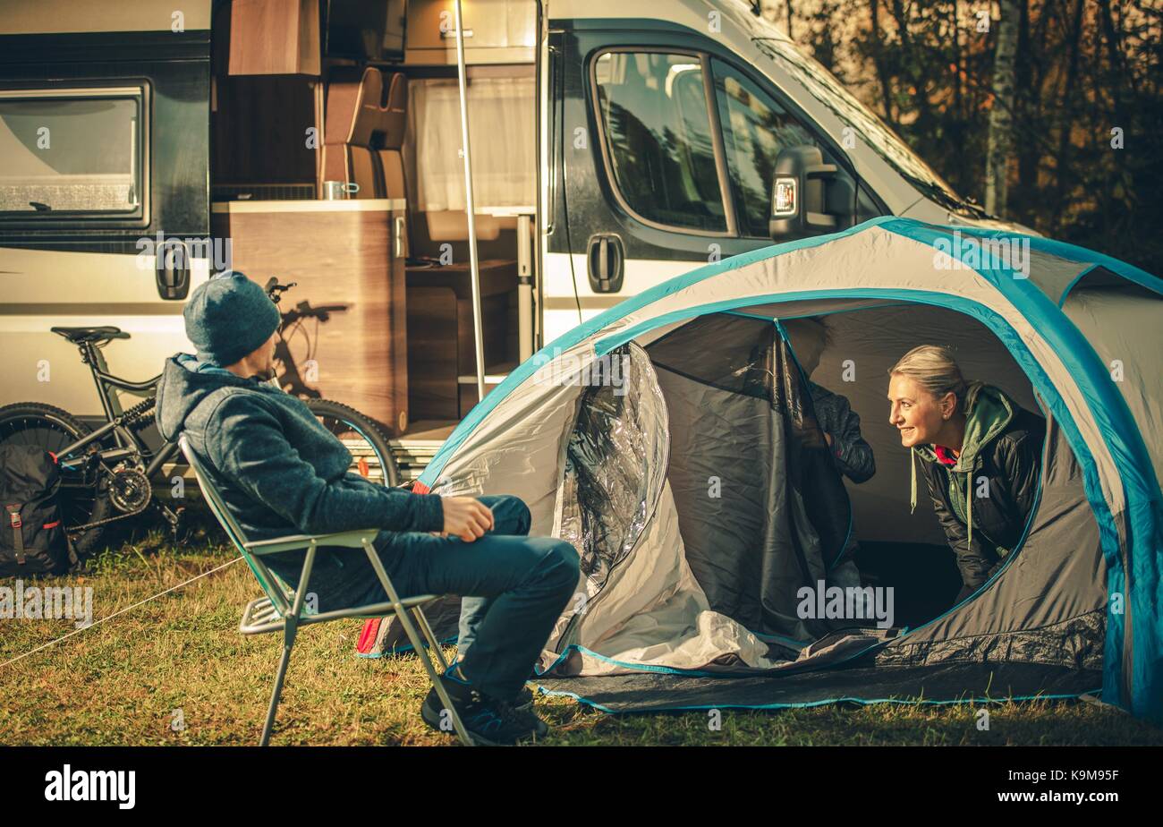 Family Camping Vacation. Motorhome and Tent on the Campsite. Caucasian Family. Stock Photo