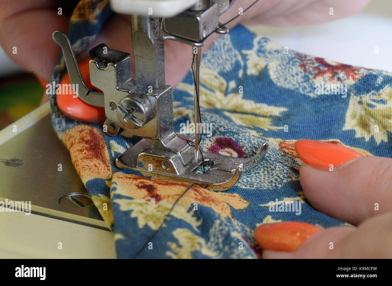 Seamstress sews on a sewing machine. Parts of sewing machine needle
