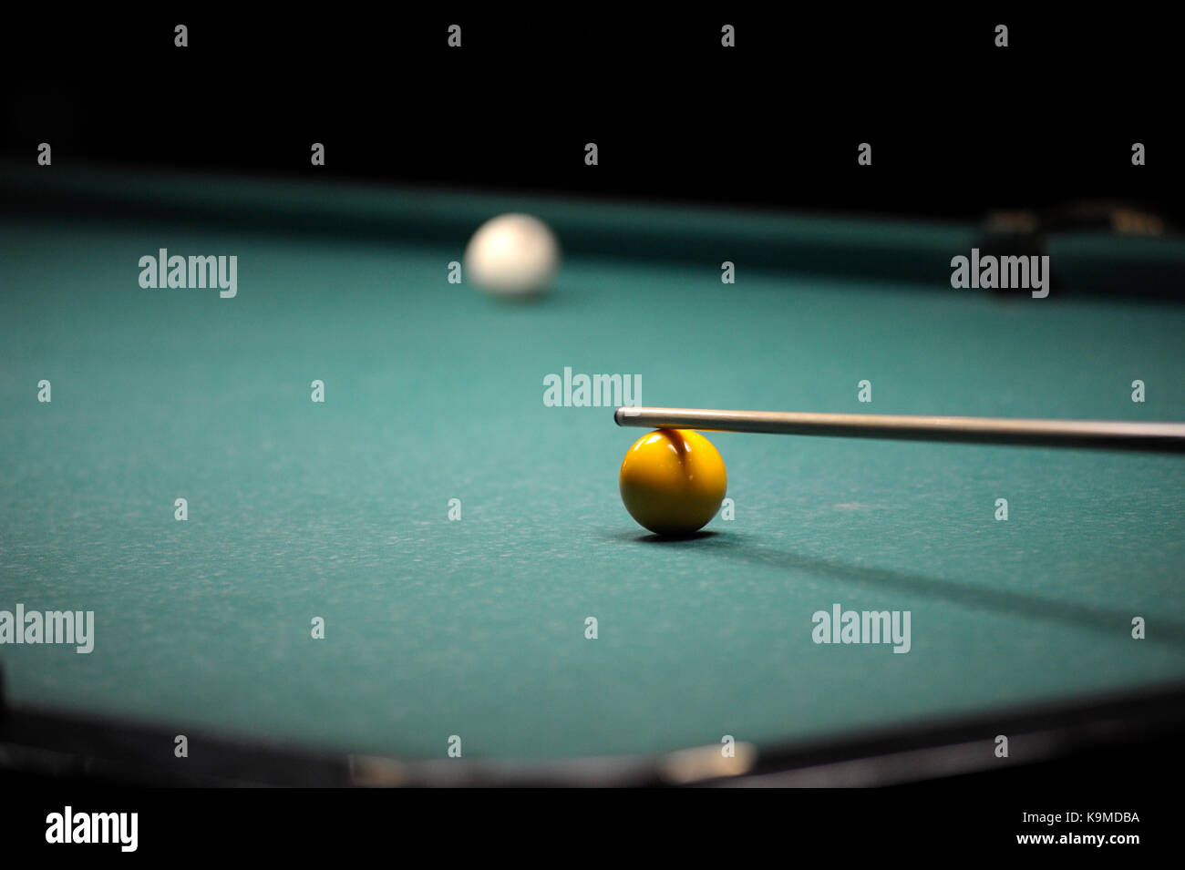A cue stick and balls on a pool table Stock Photo