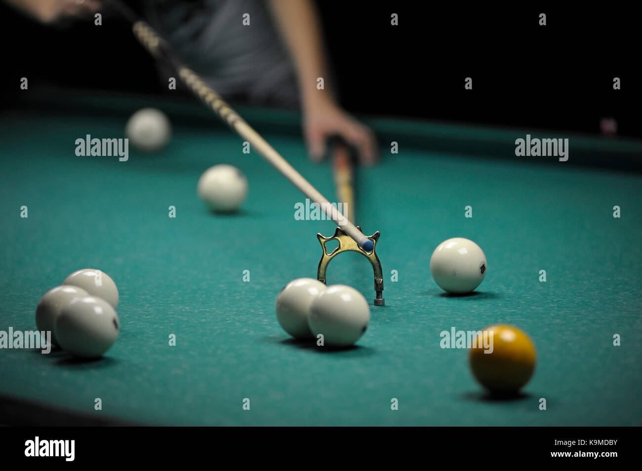 Billiard. A player's arm with a cue resting ready to stroke a ball Stock Photo