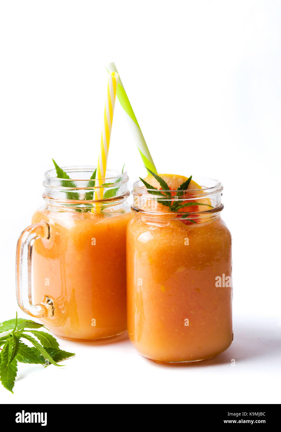 Grapefruit smoothie with marijuana leaves in jars Stock Photo