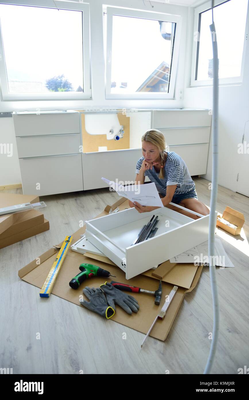 Woman reading assembly instructions at home Stock Photo Alamy
