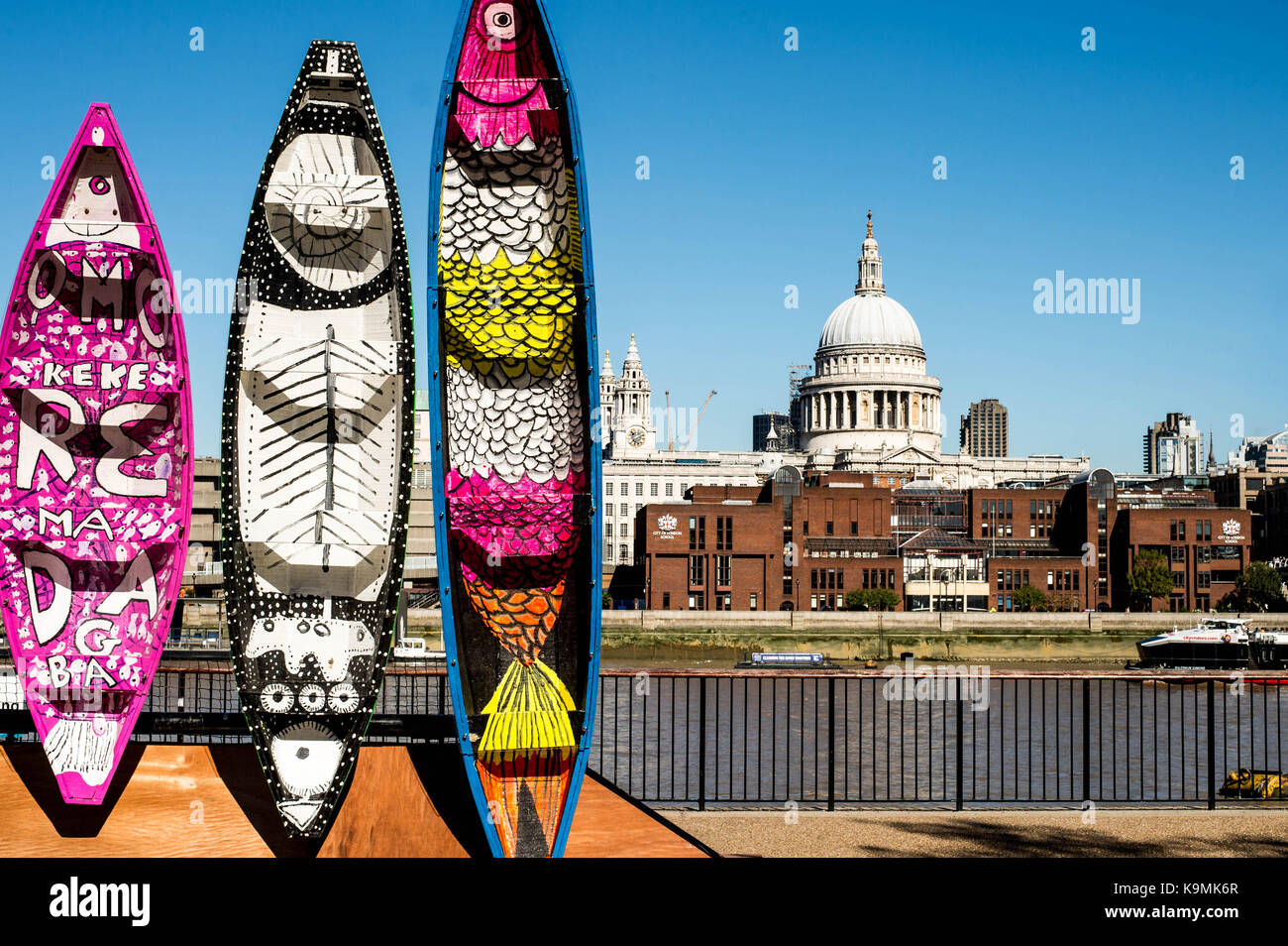 Display of Colourful Decorated Wooden Canoes on the South Bank of the Thames Opposite the Tate Modern Art Gallery Stock Photo